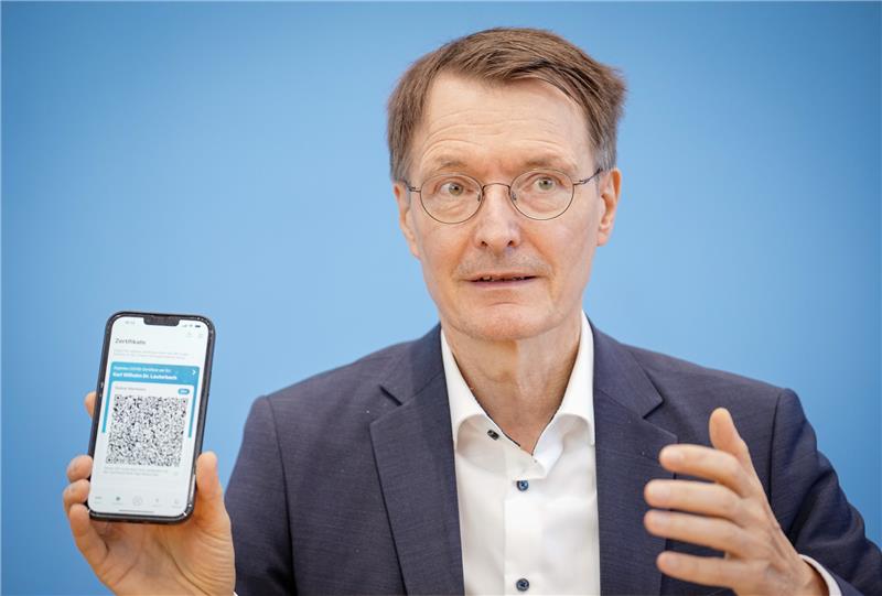 Karl Lauterbach (SPD), Bundesminister für Gesundheit, zeigt während der Pressekonferenz zur aktuellen Corona-Lage seine Coronawarn-App. Foto: Kay Nietfeld/dpa