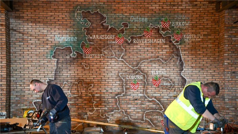Karls Erlebnis-Dörfer sind auf einer Karte an der Wand der neuen Markthalle mit einer Erdbeere markiert.