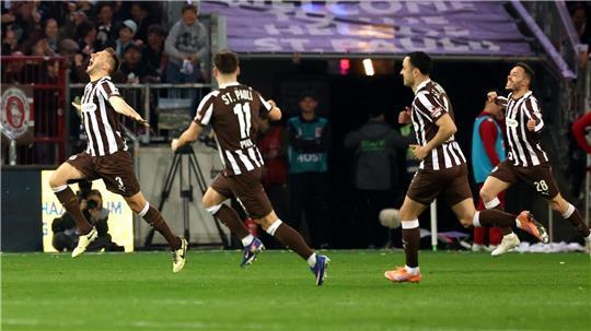 Karol Mets (l, FC St. Pauli) feiert sein 1:0 Treffer mit seinen Mannschaftskollegen.