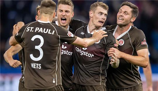 Karol Mets (l) und Teamkollegen von FC St. Pauli bejubeln den Sieg. Foto: Andreas Gora/dpa