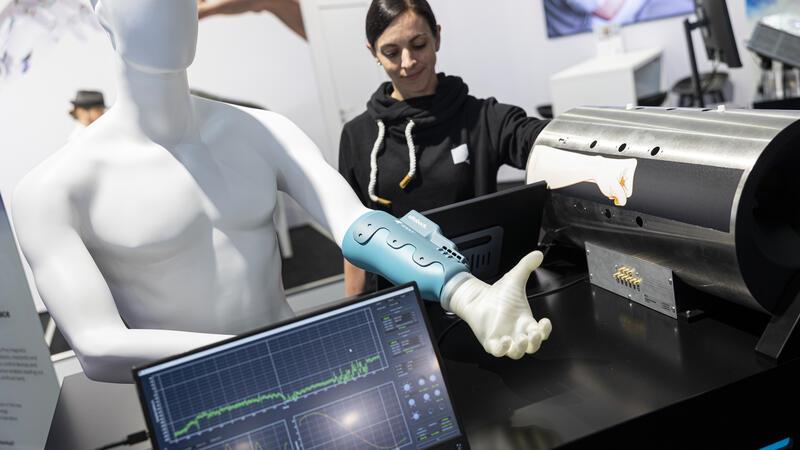 Katharina Jag-Lauber, Mitarbeiterin der Firma Q.ANT, demonstriert am Messestand der Firma ein Human Machine Interface, welches mittels Magnetfeldsensor, Biosignale vom Menschen detektieren und für eine Maschine übersetzen kann.
