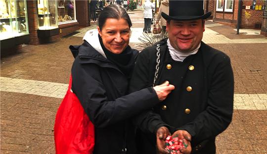 Kathleen Leuckert aus Stade reibt in der Hökerstraße mit den Fingern über die goldenen Knöpfe der Schornsteinfeger-Montur von Michael Dohrendorf. Das soll Glück bringen. Foto: Strüning