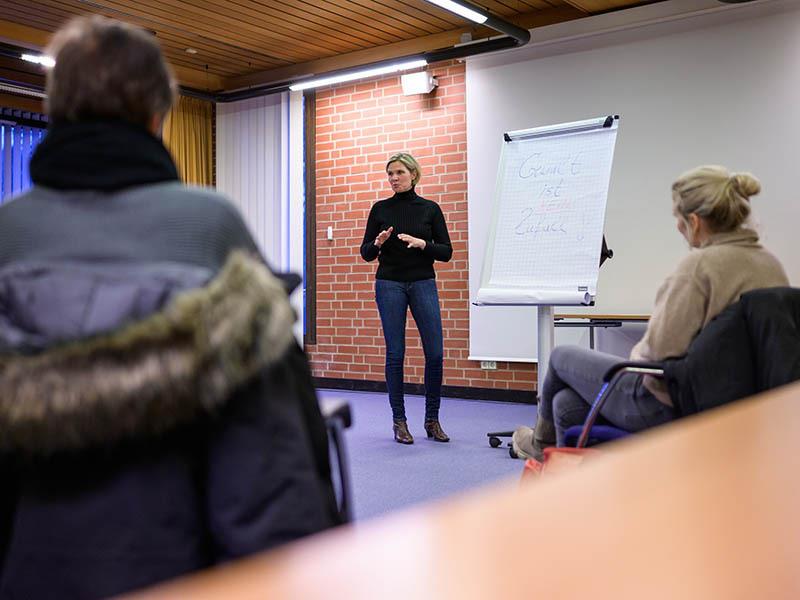 Kathrin Richter (M), Beauftragte für Kriminalprävention der Polizei, referiert in der Lüneburger Polizeiinspektio vor einer Gruppe Frauen zum Thema "Wie schützen sich Frauen?" (gestellte Szene). Foto: Philipp Schulze/dpa