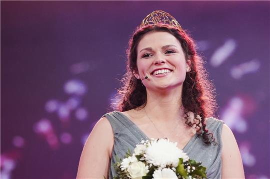 Katrin Lang, die neu gewählte Deutsche Weinkönigin, freut sich 2022 im Saalbau bei der Wahl der 74. Deutschen Weinkönigin. Die Deutsche Weinkönigin gilt als wichtigste Botschafterin der Branche und vertritt rund 15.000 deutsche Winzer ein Jahr lang bei vielen Terminen auch im Ausland. Foto: Uwe Anspach/dpa
