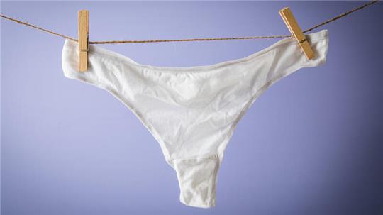 Eine Unterhose hängt auf einer Wäschleine.