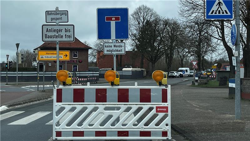 Eine Absperrung steht an der Straße, die zum Bahnübergang Vordamm/Postmoor nahe der B73 in Horneburg führt.