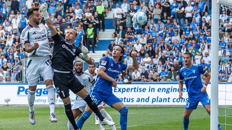 Karaman sichert Schalke Punkt in Magdeburg Kenan Karaman (l) springt höher als Magdeburgs Torwart Dominik Reimann und trifft.