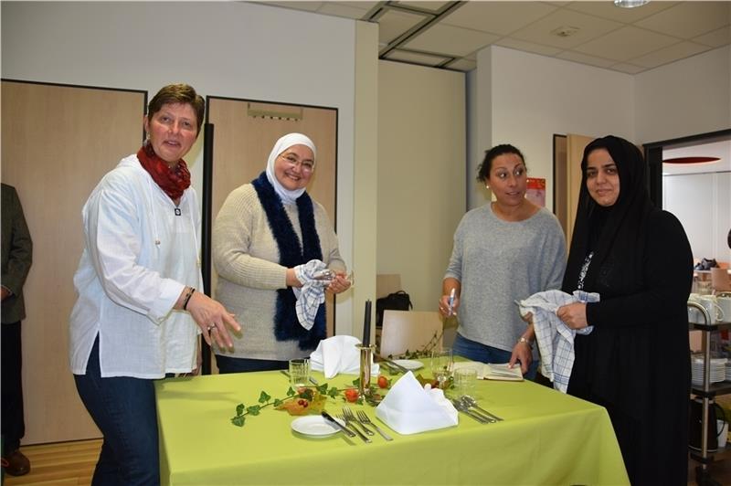 Kerstin Homann zeigt Laila Al Sayed, Tamara Baryshew und Shnna Ali, wie der Tisch besonders hübsch eingedeckt wird. Foto: Felsch