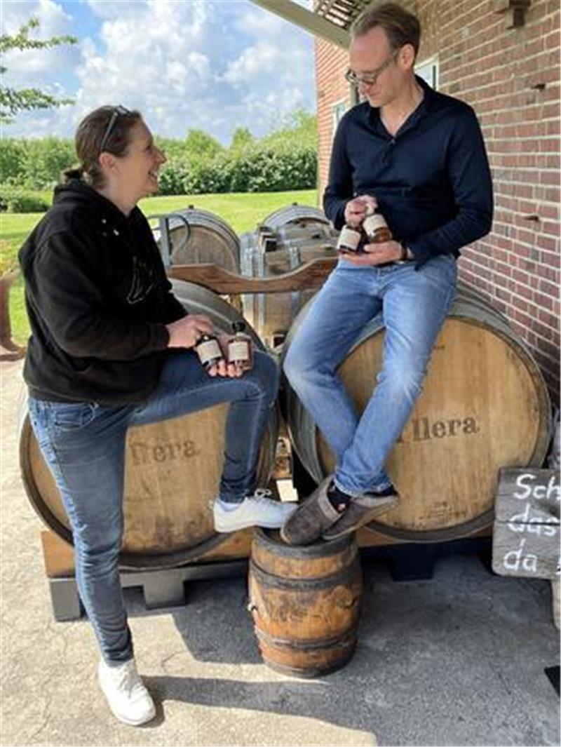Kerstin und Danny Riewoldt sitzen auf Fässern vor ihrer Genusswerkstatt.