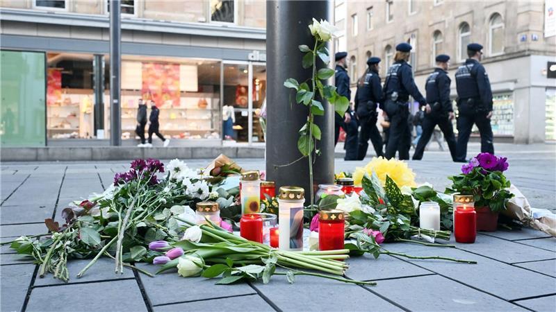 Kerzen und Blumen liegen in der Nähe des Paradeplatzes in Mannheim an einer Straßenbahnhaltestelle. (Archivfoto)