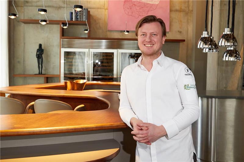 Kevin Fehling, Spitzenkoch, steht in seinem Restaurant "The Table" an einem Tisch. Wie schon in den Vorjahren wird er in der Deutschland-Ausgabe des Restaurantführers "Guide Michelin" 2023 mit drei Sternen ausgezeichnet. Foto: Georg Wendt/dpa