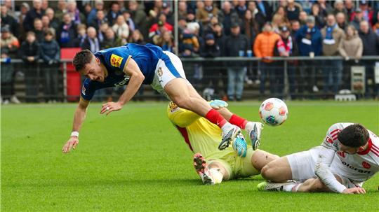 Kiels Adrian Kapralik (l) prallt mit Nürnbergs Jan Reichert zusammen.