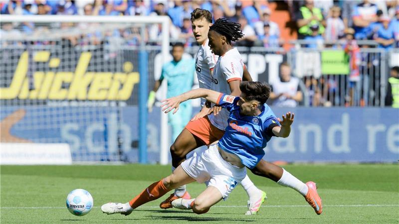 Freiburg siegt und besiegelt den Abstieg von Holstein Kiel Kiels Armin Gigovic (vorn) im Zweikampf mit Freiburgs Johan Manzambi.