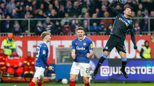 Kiels Nicolai Remberg (M) feiert neben dem Kieler Niklas Niehoff (l) beim Abpfiff den Sieg.