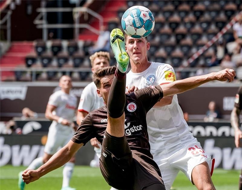 Kiels Simon Lorenz (l) und Kiels Phil Neumann kämpfen um den Ball. Foto: Axel Heimken/dpa