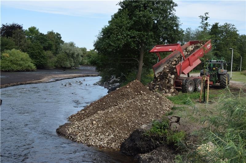 Kies wird in den Teich geschüttet, um das Wasser der Este in einen Umfluter zu lenken.