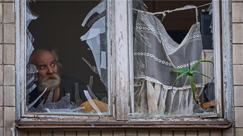 Kiew nach Drohnenangriff: Alter Mann blickt aus zerstörtem Fenster