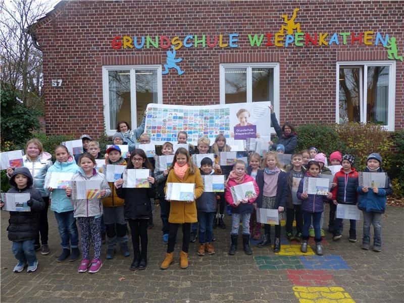Kinder der vierten Klasse der Grundschule Wiepenkathen zeigen ihre Bilder. Das große Poster halten Sandra Männel (links) und Mira Bonneval.