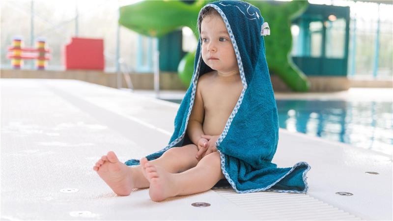 Kinder empfinden Kälte anders: Nach dem Schwimmen warm einpacken.