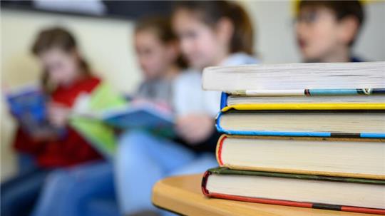 Kinder lesen in einer Grundschule. Ab 2026 soll es für sie eine verlässliche Ganztagsschule geben. Foto: Sebastian Gollnow/dpa