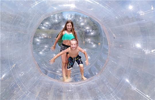 Kinder spielen in der begehbaren Riesenschwimmblase.