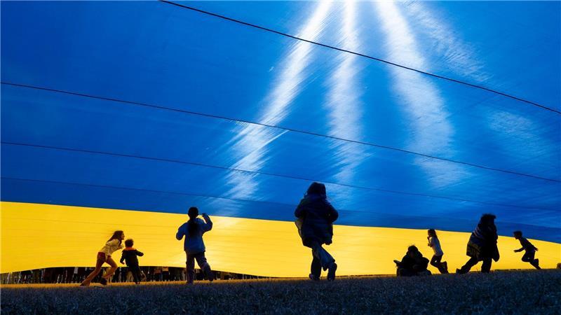 Kinder spielen unter einer ukrainischen Fahne während einer Kundgebung zur Unterstützung der Ukraine in der Nähe des Weißen Hauses in Washington.