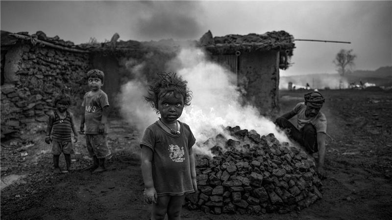 Kinder stehen in einem Kohlefeld von Jharia in Indien.