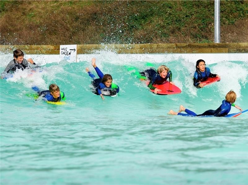 Kinder üben auf einer kleinen Welle das Surfen, so könnte es auch in Stade bald aussehen. Foto: Wavegarden