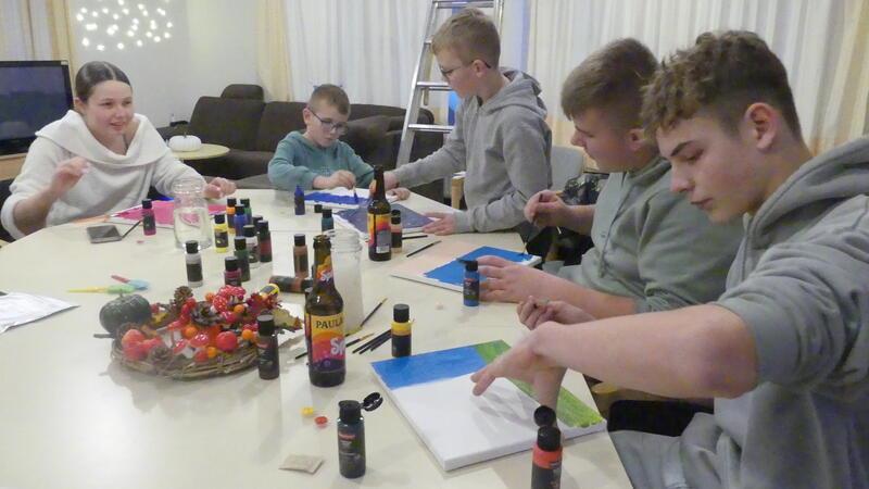 Kinder und Jugendliche aus den Elbstromdörfern malen hier gerade Acrylbilder, um die Wände des Jugendtreffs damit zu dekorieren. Vorne rechts Lauren, der zu den Stammbesuchern gehört.