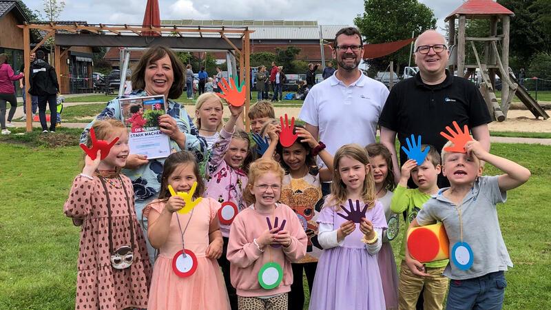 Mehr Bewegung im Kita-Alltag: Projekt der IKK classic war erfolgreich Kita-Leiterin Stefanie Richter, Stephan Jahn und Dennis Walther freuen sich mit den Kindern über den Erfolg.