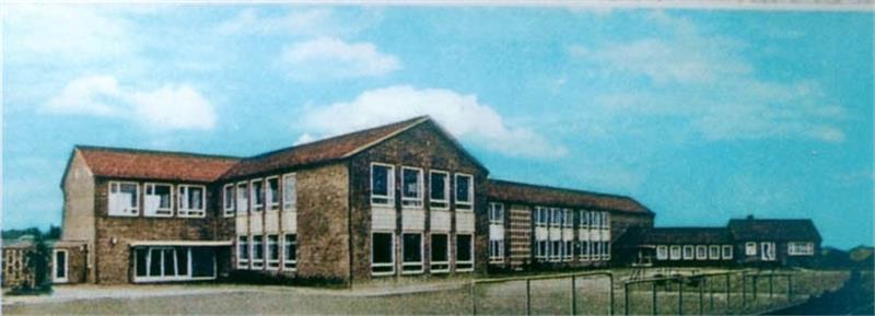 Klassische Flurschule aus der Adenauer-Zeit: Die Postkarte zeigt das Hauptgebäude der heutigen Grundschule kurz nach dem Bau im Jahre 1959.