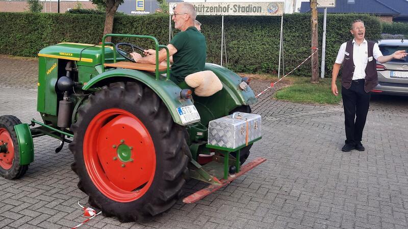 Schnapsidee: Mit dem Porsche in Ahlerstedt zum halben Preis essen Klaus-Dieter Bockelmann (rechts) leitet die Trecker zum Platz. Hinter dem Haus steht sein eigenes Schätzchen: ein Deutz Baujahr 1979.