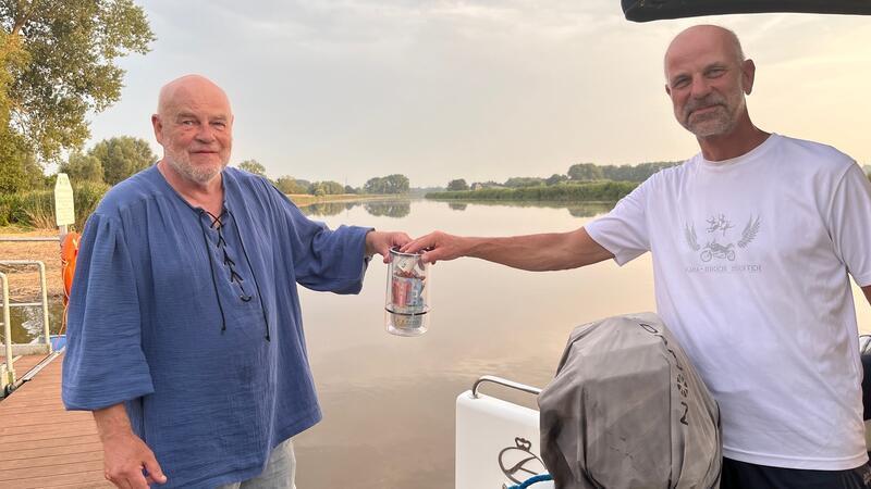 Klaus Eisner geht für die Band mit dem Hut rum, der in diesem Fall ein Weinkühler ist. Martin Peters aus Oberndorf hat mit seinem Boot am Steg festgemacht und gibt gerne einen Obolus für die Musik.