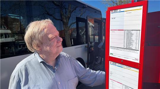 Klaus Müller vom Fahrgastbeirat schaut auf einen KVG-Fahrplan am Altländer Markt in Jork.