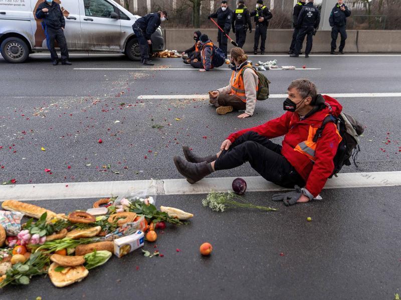 Klimaaktivisten der Gruppe „Aufstand der letzten Generation“ haben ihre Hände auf die Autobahn geklebt. Foto: Carsten Koall/dpa