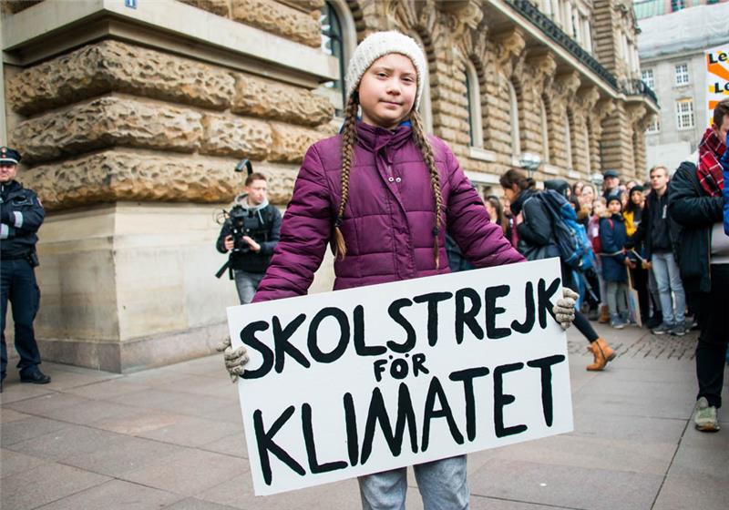 Klimaaktivistin Greta Thunberg steht mit ihrem Transparent "Skolstrejk for Klimatet" vor einer Kundgebung dem Hamburger Rathaus. Kommende Woche zieht Thunberg als Wachsfigur ins Panoptikum auf St. Pauli. Foto: Daniel Bockwoldt/dpa