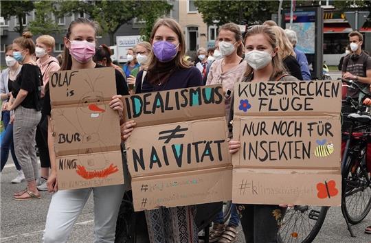 Klimaaktivistinnen halten Plakate während einer Demonstration des Bündnisses Fridays for Future hoch. Foto: Luise Evers/dpa