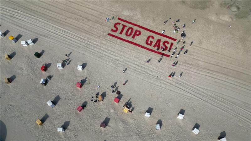 Protest gegen „Riesen-Klimakiller“ - EWE liefert Borkum-Gas Klimaschutzaktivisten von Fridays for Future schreiben ihre Forderung nach einem Ende der Gasförderung auf den Strand der Insel Borkum.