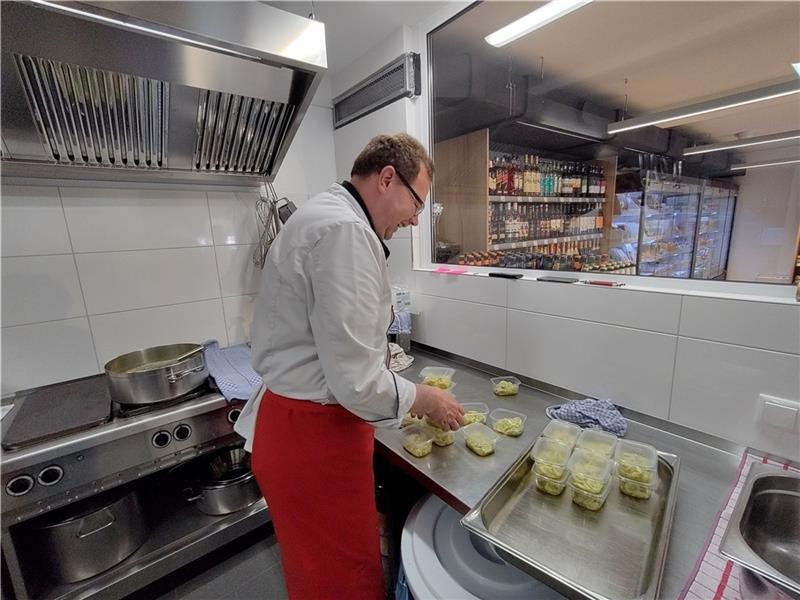 Kochen mit Blick auf den Verkaufsraum : Michael Kaiser füllt Gurkensalat in Töpfchen. Fotos: Lohmann