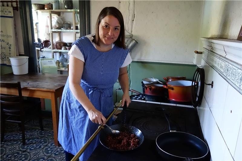 Kochen wie früher: Ilka Lapschieß am Herd in einem der historischen Häuser im Freilichtmuseum am Kiekeberg. Die ehrenamtliche Mitarbeiterin ist seit 2010 dabei und empfindet ihr Ehrenamt als einen Ausgleich zum Bürojob. Foto: FMK