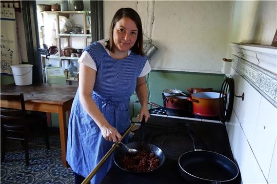 Kochen wie früher: Ilka Lapschieß am Herd in einem der historischen Häuser im Freilichtmuseum am Kiekeberg. Die ehrenamtliche Mitarbeiterin ist seit 2010 dabei und empfindet ihr Ehrenamt als einen Ausgleich zum Bürojob. Foto: FMK