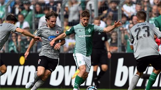Kölns David Philipp (l) und Bremens Romano Schmid kämpfen um den Ball.