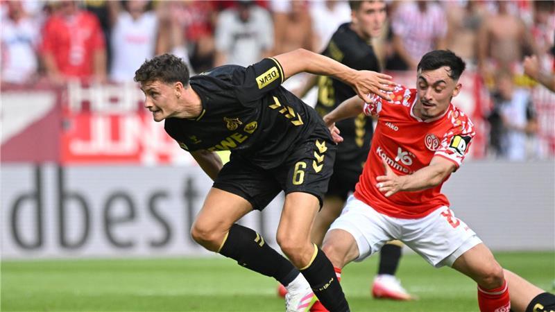 „Kein Gaumenschmaus“: Köln siegt bei Bundesliga-Rückkehr Kölns Eric Martel (l) blockt den Mainzer Paul Nebel ab.