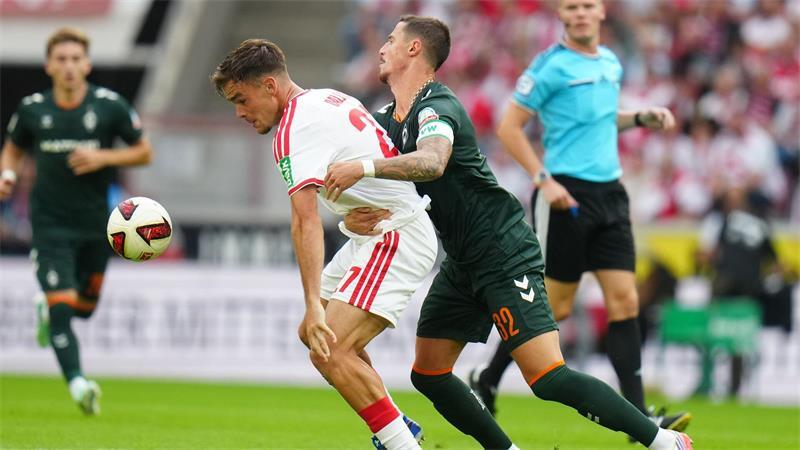 Kölns Thijs Dallinga (l) und Bremens Marco Friedl kämpfen ums den Ball.