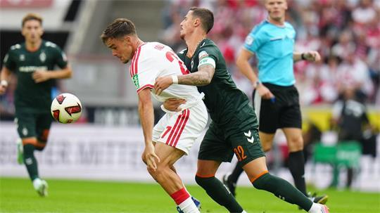 Kölns Thijs Dallinga (l) und Bremens Marco Friedl kämpfen ums den Ball.