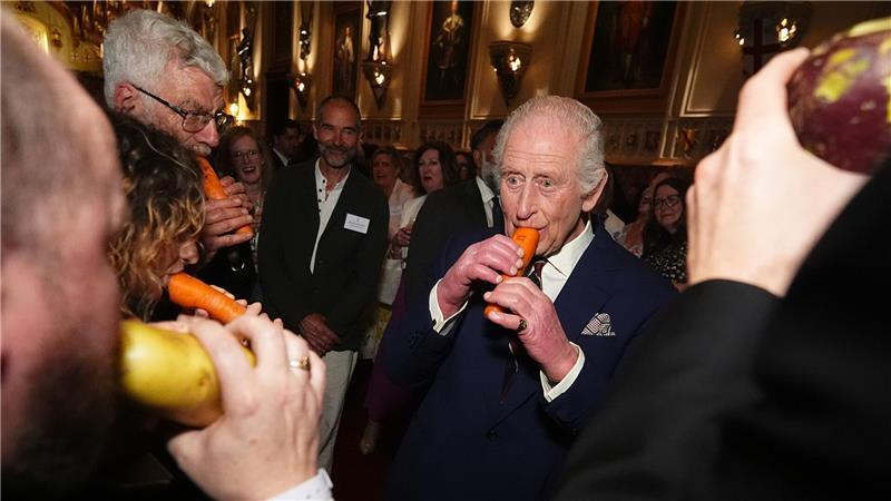 König Charles III. spielt eine Karottenflöte mit dem London Vegetable Orchestra auf Schloss Windsor.