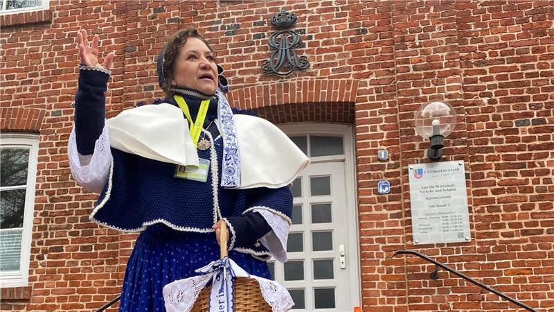 Königliches Monogramm: Von Marlene Plate lernen die Gäste, was das Zeichen über dem historischen Gebäude beim Platz am Sande mit der Flutkatastrophe von 1717 zu tun hat.