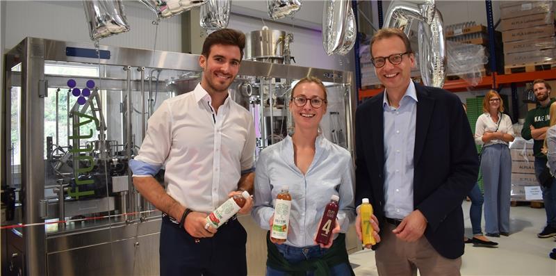Konstantin Timm und Annemarie Heyl von „Kale & Me“ und Ulf Wittlich von der Elbe-Obst vor der Abfüllanlage ihres gemeinsamen Produktionsunternehmens Nordsaft (von links). Rund 3000 Flaschen können pro Stunde abgefüllt werden, vier Mitarbeiter arbeiten in der Produktion. Foto Vasel
