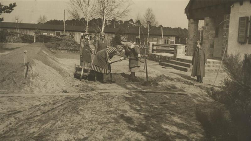 Konzentrationslager Ravensbrück: Häftlingsfrauen bei Erdarbeiten im Bereich der SS-Wohnsiedlung unter Aufsicht einer Aufseherin, SS-Propagandafoto, um 1941.