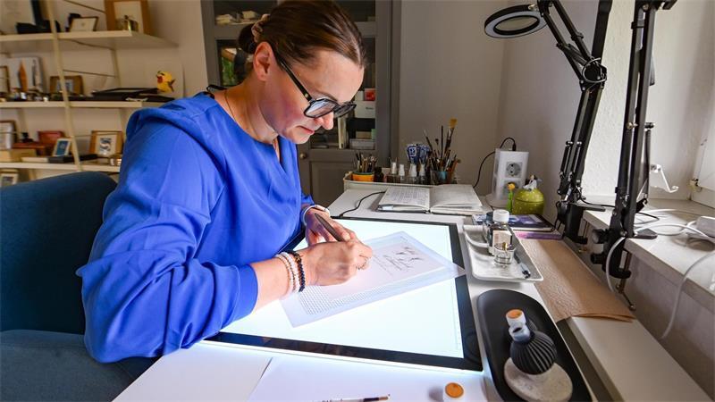 Konzentriert schreibt Zuzana Gajdosikova in ihrem Atelier in Kührstedt mit Feder und Tinte auf feinem Papier.